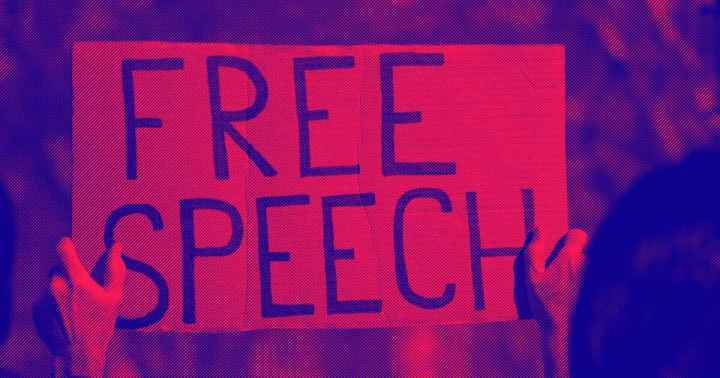 A protester holds a sign that says, "Free Speech."