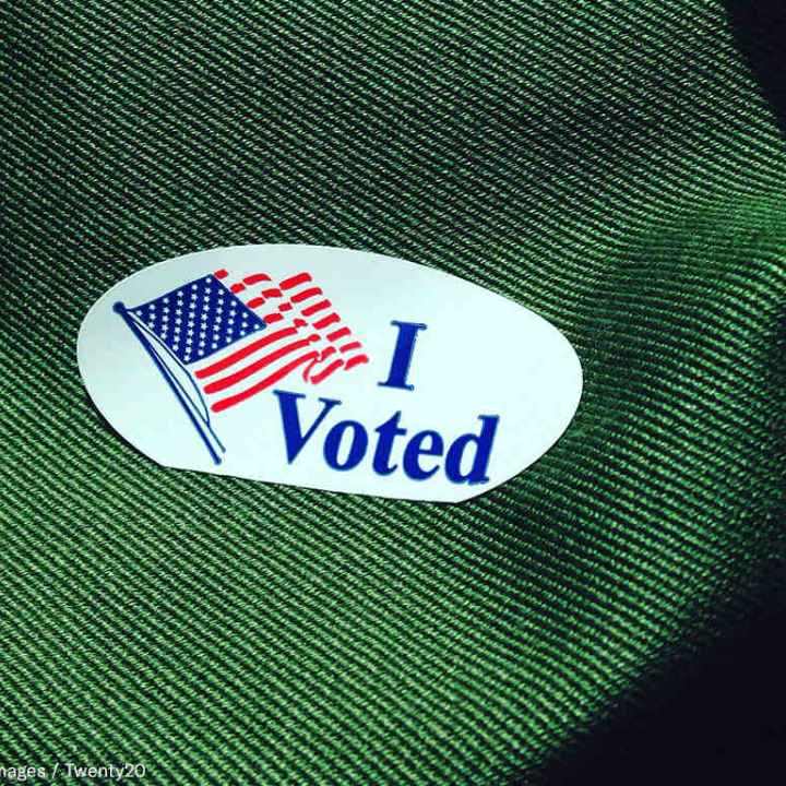 Photo of a sticker that says "I voted" with a waving American flag