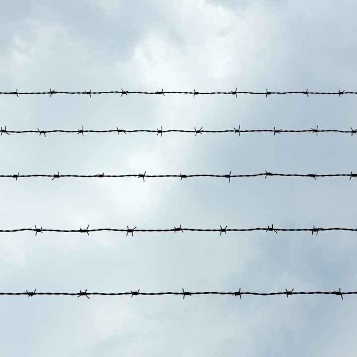 A photo of prison wire against a sky